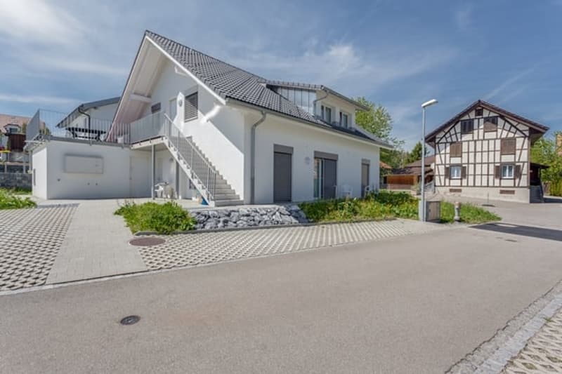 2 story house, white exterior, gray roof, balcony, driveway, garden