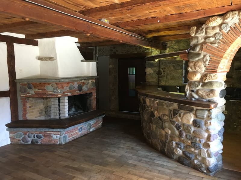 room with a fireplace and a wooden plank in front of it, wooden beam ceiling, wooden floor