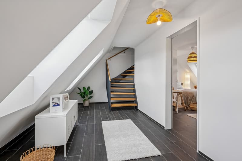dark wooden floor, white walls, white cabinet, decorative picture frame, staircase, small rug