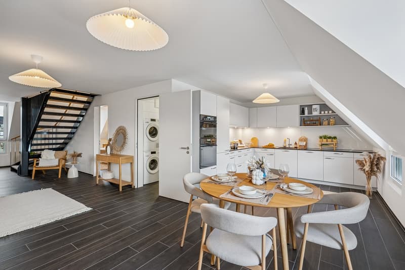 Open plan kitchen and dining area, modern furniture, white decor, round dining table, large windows, white flooring, black railing
