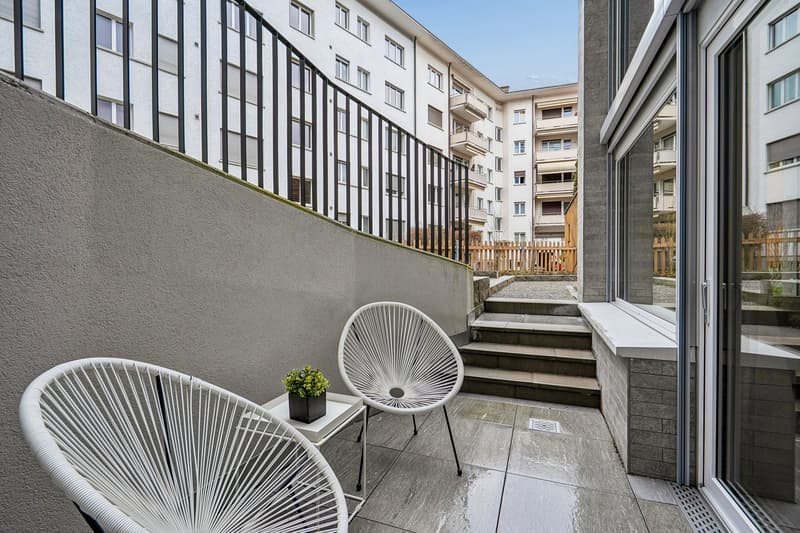 Modern balcony with two chairs and a plant, raised ground floor, staircase, metal railing