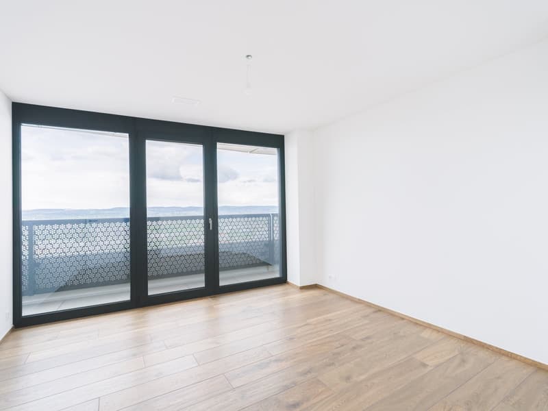 empty room, wooden floors, sliding glass doors, balcony with decorative fencing, white walls