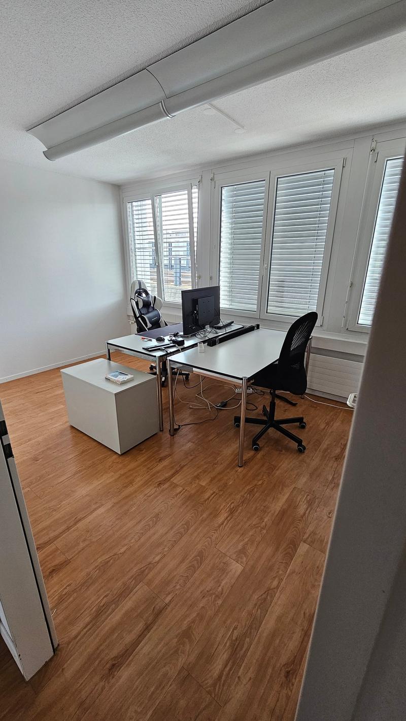 room with two desks, one with a black office chair, other with a gaming chair, monitor and books