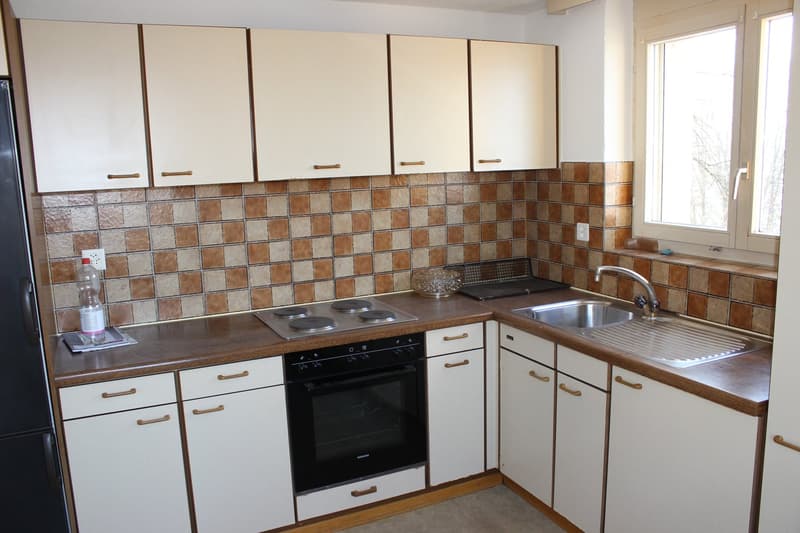 white cabinets, tiled backsplash, gas stove, oven, sink, faucet, refrigerator