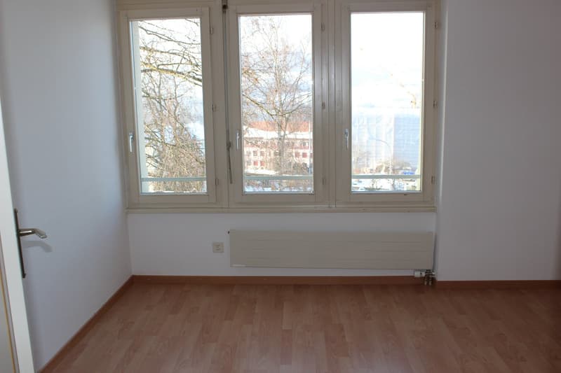 empty room, white walls, wooden floor, large windows, heater