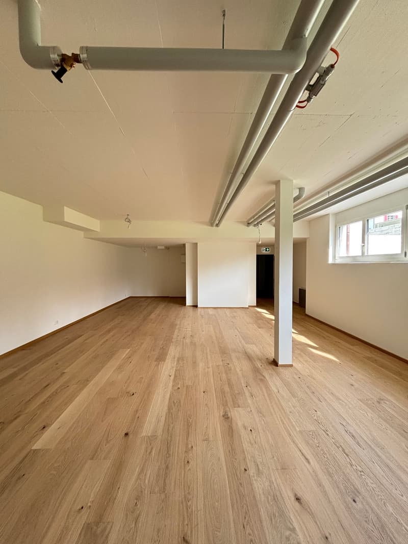 empty room, wooden floor, white walls, pipes on ceiling, window