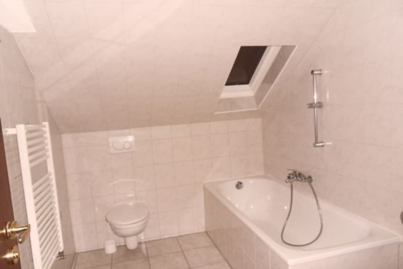 Bathroom with bathtub, toilet, and a radiator
