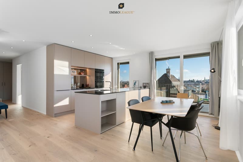 Licht, Raum und Design in Harmonie. Die hochwertige Küche mit Kochinsel verbindet sich mit dem Essbereich und wird zum Herzstück der Wohnung.