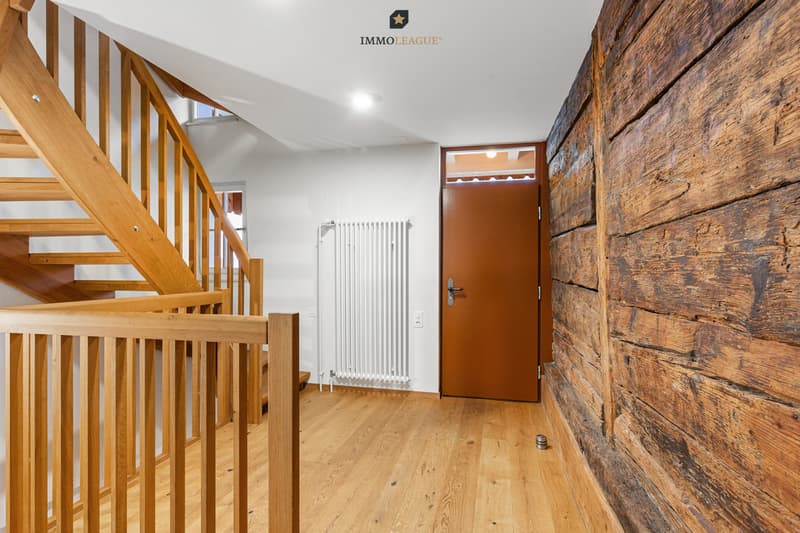 Die alte Holzwand wurde mit grosser Sorgfalt aufgearbeitet. Hier wird die Geschichte des Hauses greifbar - ebenso die Umsicht, mit der es erneuert wurde.