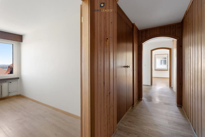 Warme Holzelemente verleihen dem geräumigen Flur mit Einbauschrank ein gemütliches Flair.