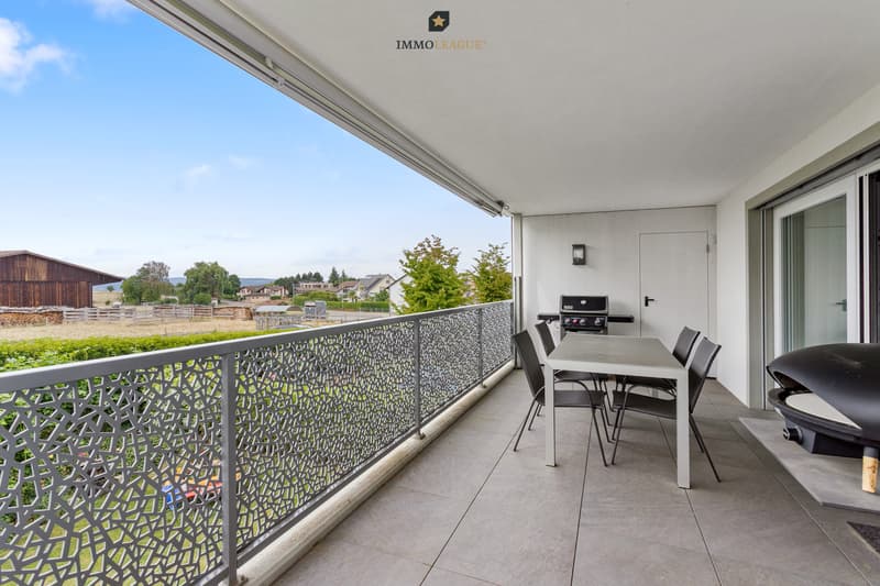 Der grosszügige, überdachte Balkon mit Sonnenstore bietet einen wunderschönen Blick ins Grüne und verfügt über ein praktisches Reduit für mehr Stauraum.