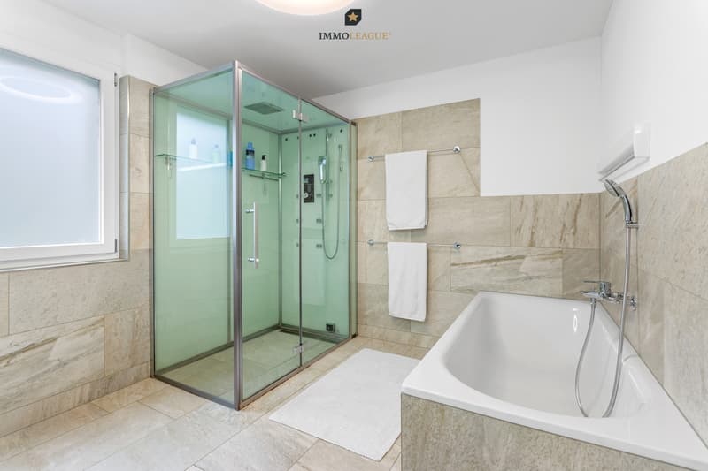 Das traumhafte Badezimmer mit viel Platz und Tageslicht verfügt über eine Badewanne sowie ein exklusives Hamam-Dampfbad. Ihre Wellnessoase zu Hause.