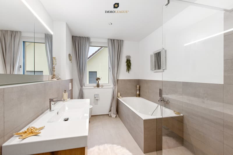 Das helle Bad en Suite besticht durch sein markantes Design.