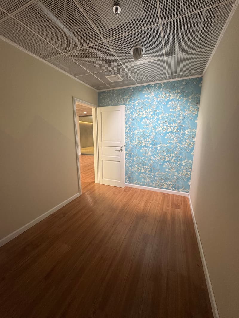 empty room, wooden floor, white ceiling, white door, blue wallpaper