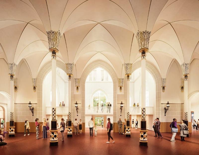 Large, ornate interior space with arched ceilings, decorative columns, and people walking around. The space has a grand, cathedral-like appearance with intricate architectural details and lighting fixtures.