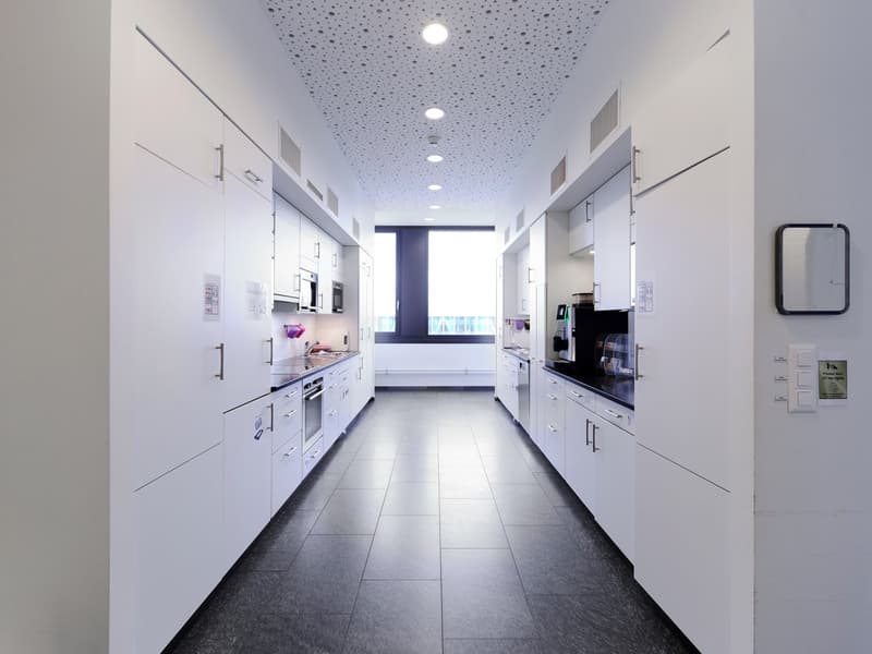 kitchen with white cabinets, black countertops, black tiled floor, oven, refrigerator, microwave, coffee machine, dishwasher, sink