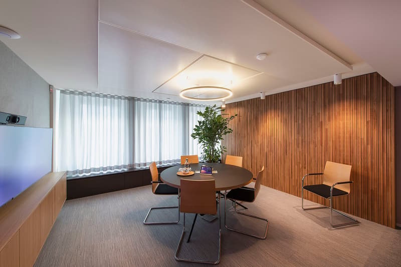 modern and simple meeting room with round table, wooden wall and curtains