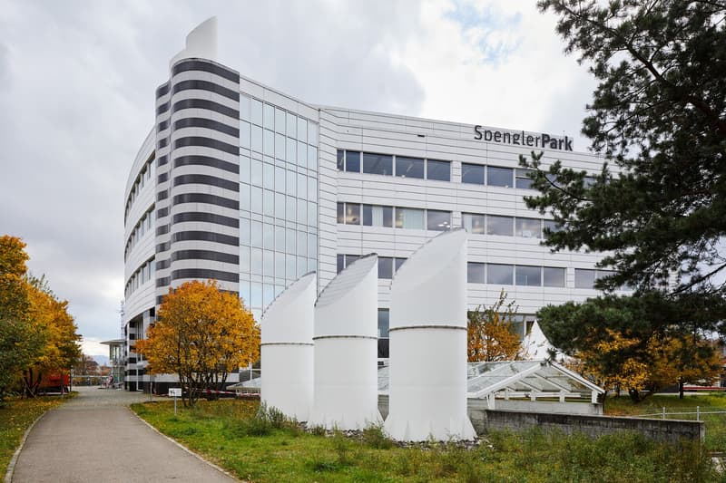 modern office building, glass windows, black and white stripes, trees, pathway, white structures