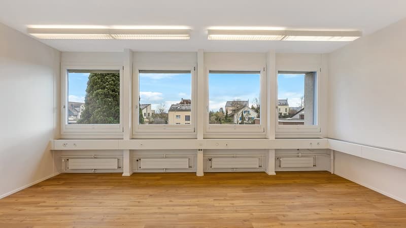 empty room, wooden floor, white walls, 4 windows, built-in bench, radiators