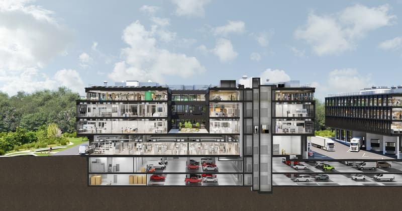 Multi-story mixed-use building with retail, office, and residential spaces. The building has a modern, transparent design with large windows and balconies. There is a parking area visible at the ground level.