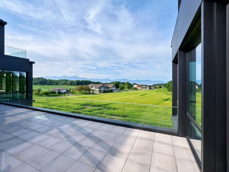 Modern balcony with floor to ceiling glass panels, large, offering wide views of the landscape
