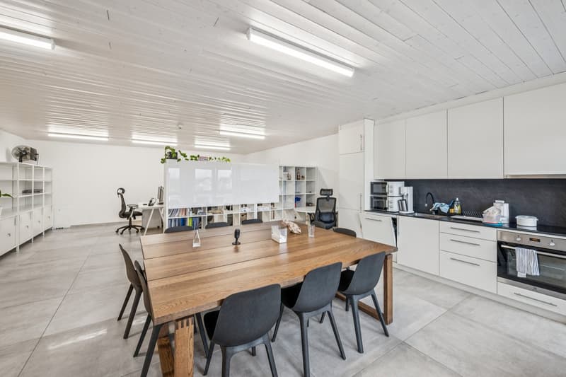 modern kitchen with wooden table, white cabinets, built-in appliances, open space, natural light