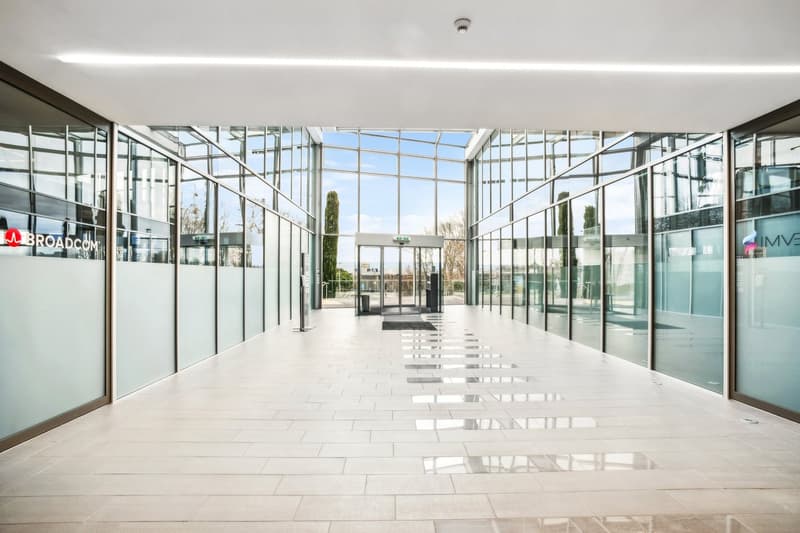 modern building, glass walls, white tiled floor, entrance with automatic doors, large windows
