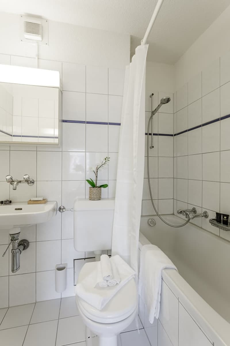 White bathroom with toilet, shower, sink and bathtub