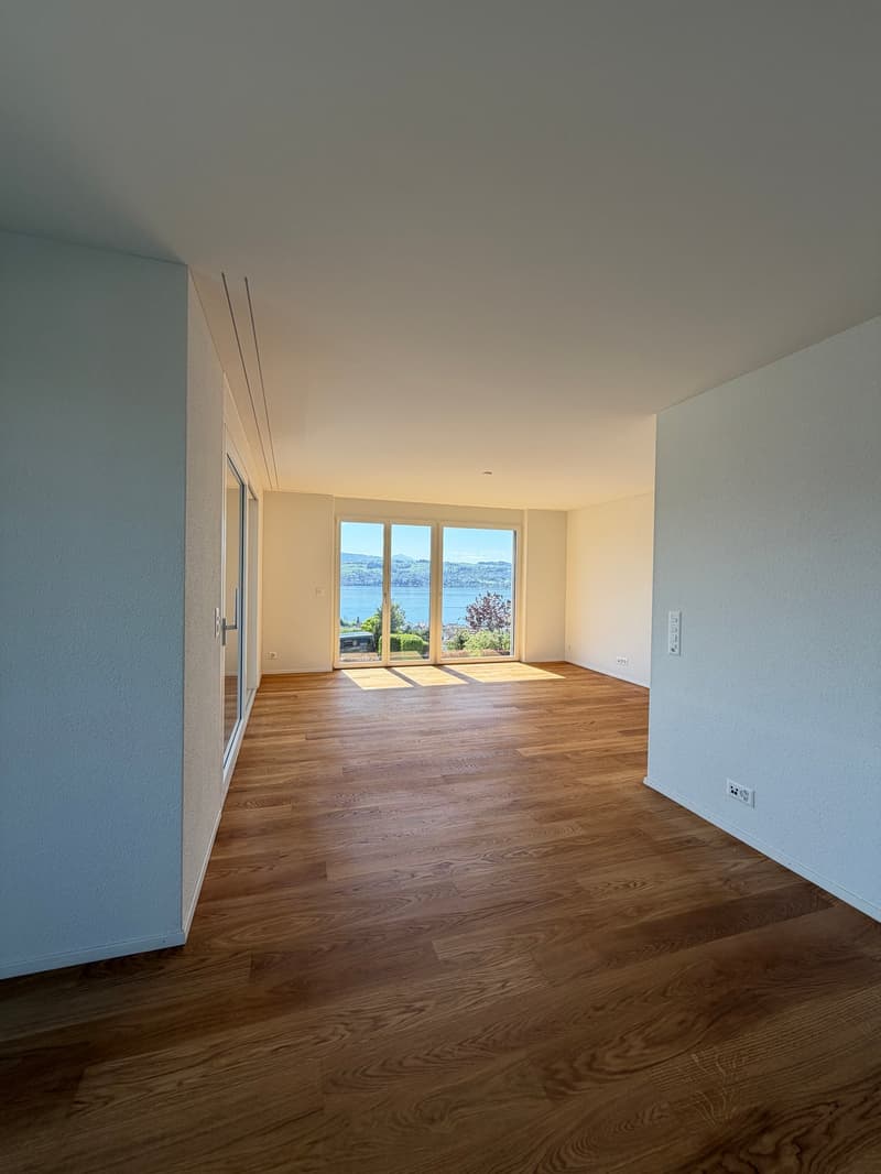 empty room, wooden floor, sliding glass doors, view of lake and mountains