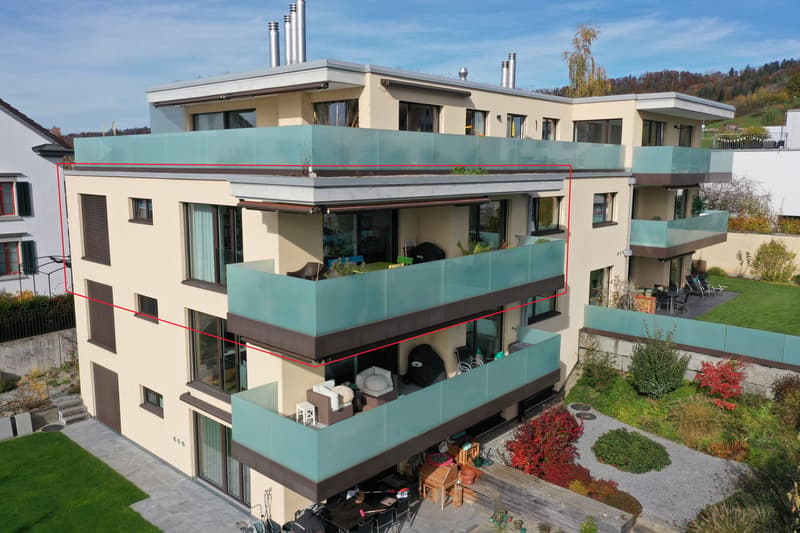 Three story house, beige facade, glass railings on all balconies