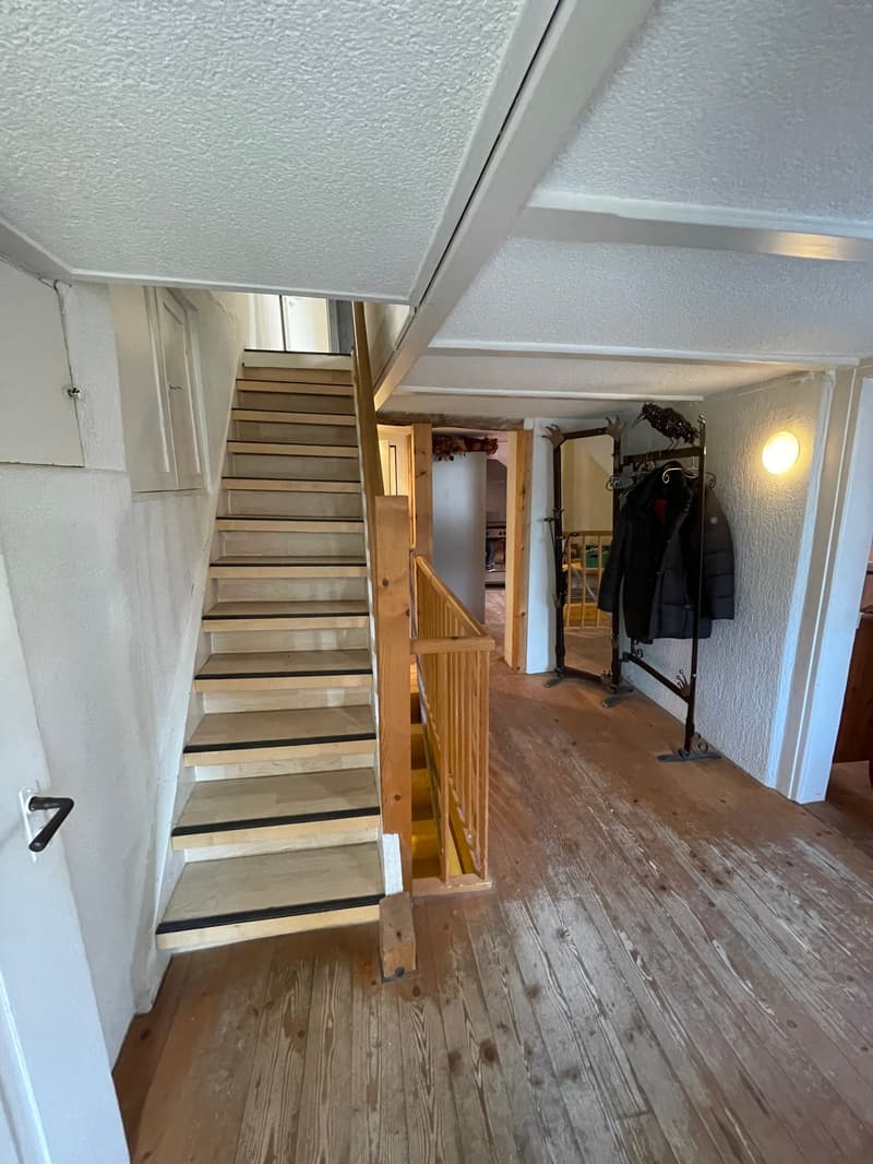 wooden staircase, wooden flooring, white walls, coat stand, mirror, doorway
