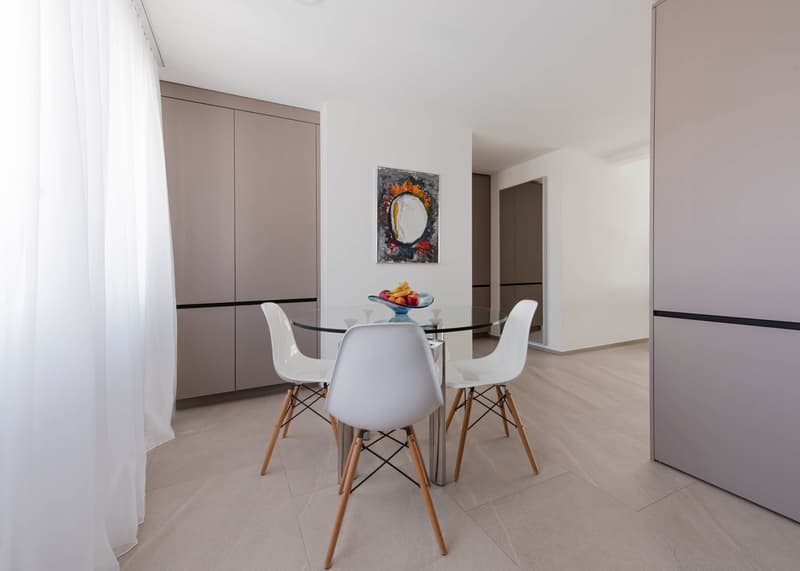 modern dining room with glass table, white chairs, modern design, neutral color palette, artwork on the wall