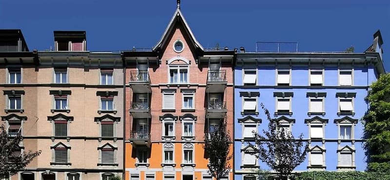 Apartment building with multiple stories and balconies, beige, orange and blue facades