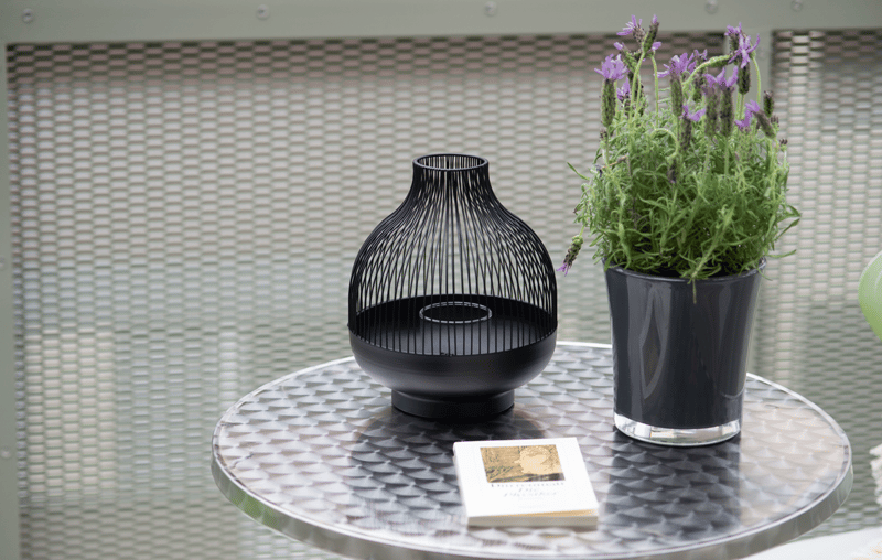 Table with a black decorative vase and a plant in a black vase on it