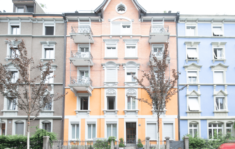 5-story apartment building, bright orange and white facade, multiple balconies, metal railings