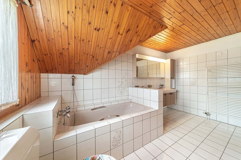 white tiled bathroom, wooden ceiling, bathtub, sink, toilet, radiator