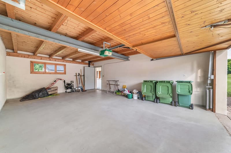 concrete floor, wooden ceiling, tools and equipment present, waste bins, wooden windows