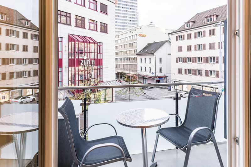 Open view of street, table and chairs on balcony