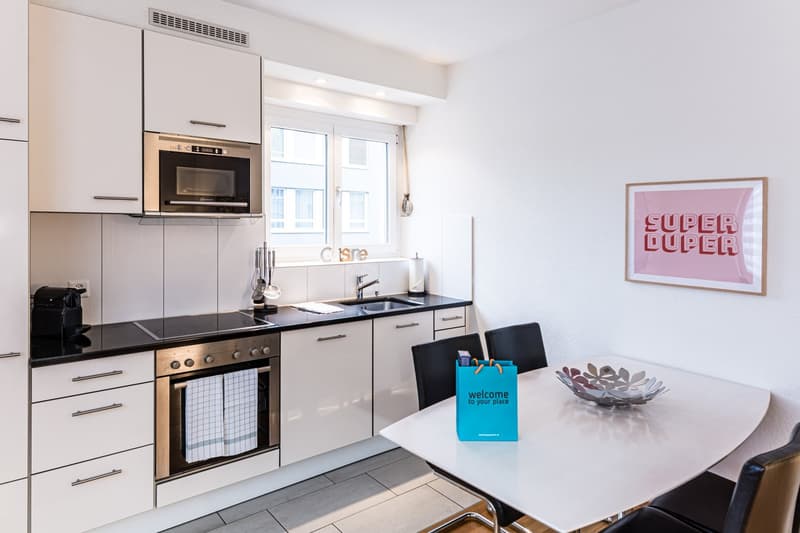 modern kitchen with a stove, oven, and microwave, sink, cabinets, dining table, chairs
