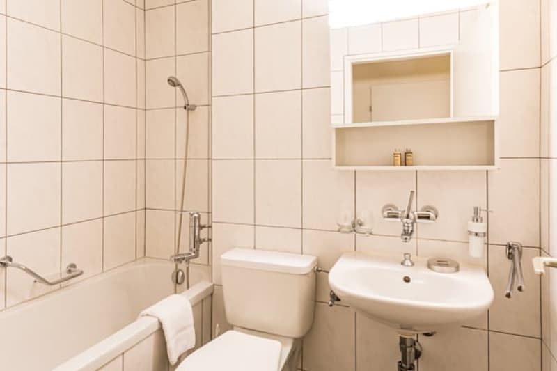 white tiles, white bathtub, white toilet, white sink, white mirror, showerhead