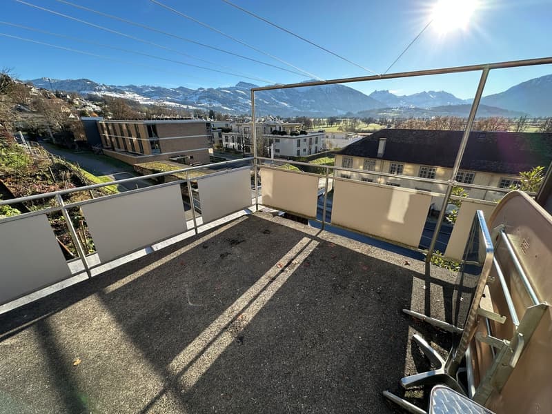 balcony with metal railings, empty, looking out to town and mountains