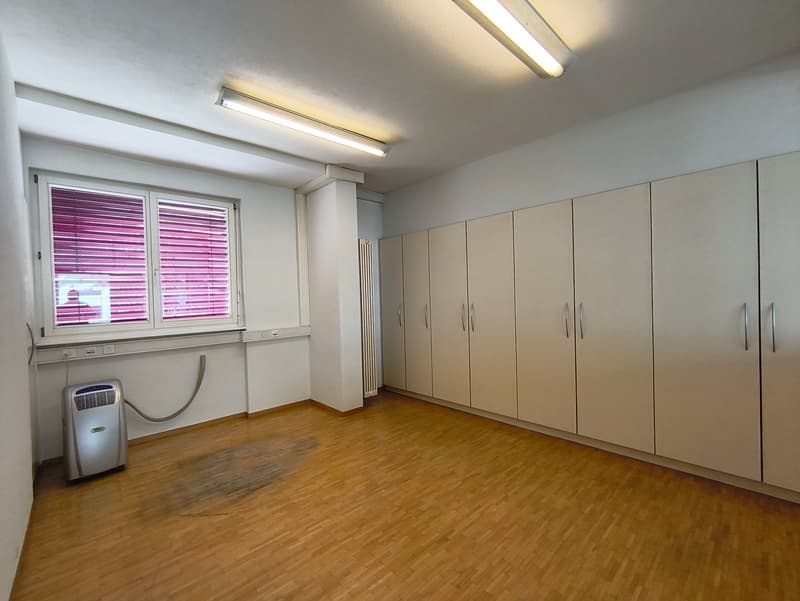 Spacious bedroom with built-in wardrobes, hardwood flooring, and a window with purple blinds. The room also has a portable air conditioning unit.