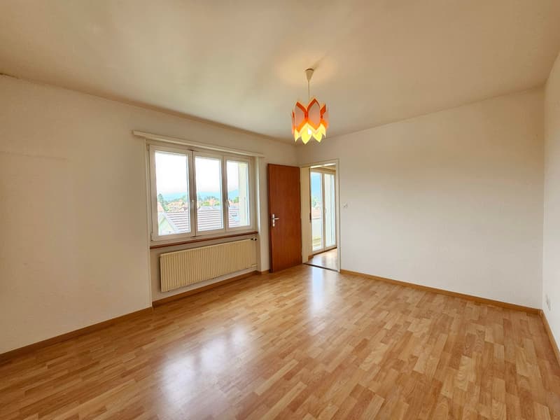 empty room, hardwood floors, white walls, windows, sliding doors, white radiator, hanging lamp