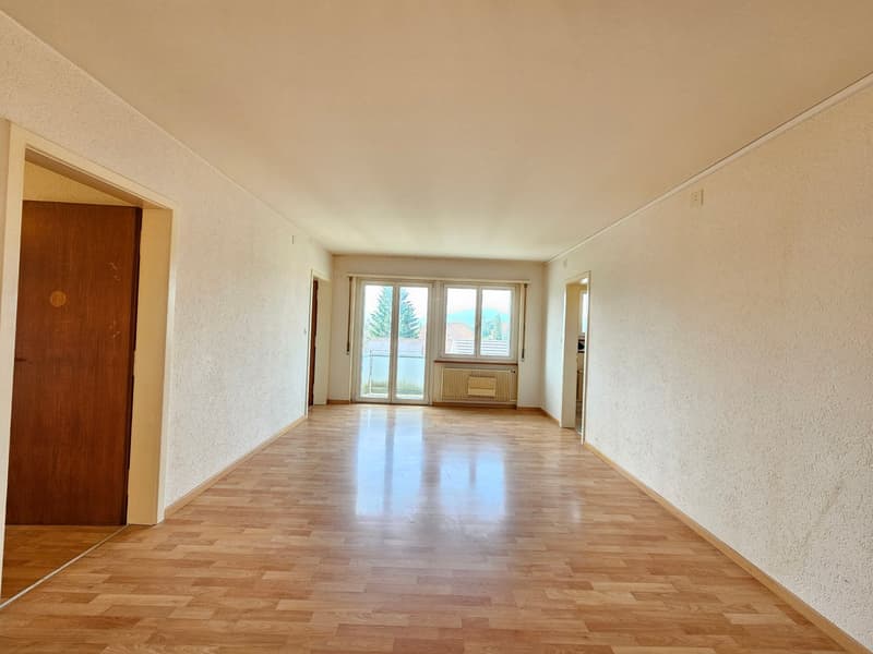 wooden flooring, white walls, two windows with sliding doors, heating system under window, wooden door, wide open space