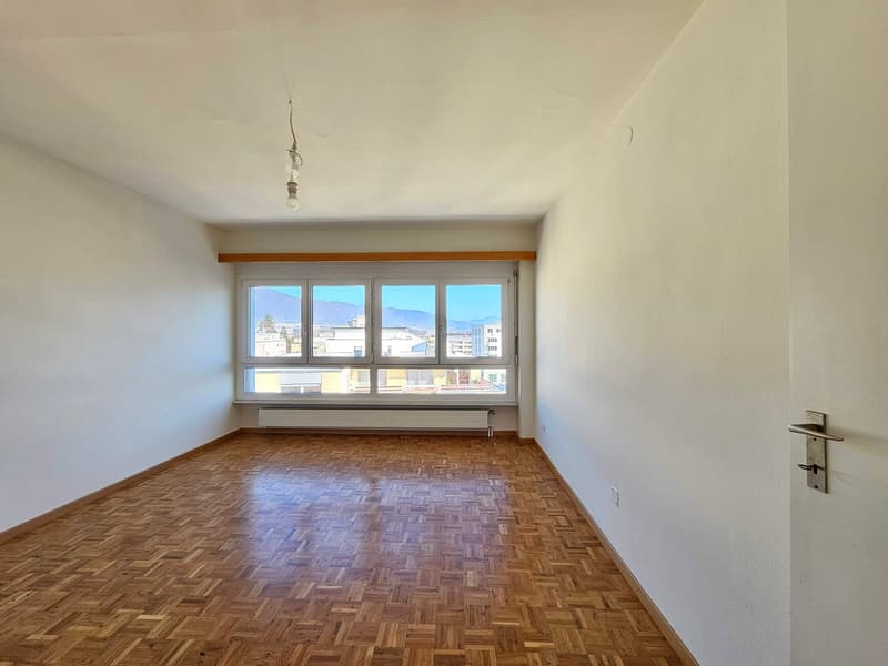 large window, wooden floor, white walls, hanging light, no furniture
