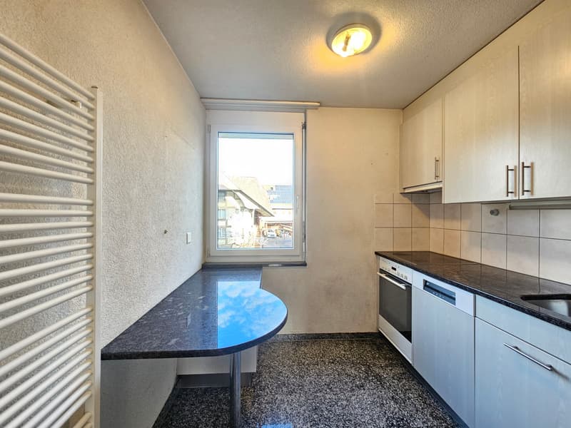 Open kitchen, granite countertop, integrated dishwasher, modern appliances, white cabinetry, black tiled backsplash
