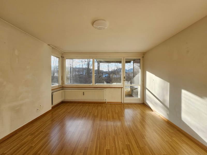 empty room with hardwood floors, glass windows, white walls, white ceiling, two radiators, power outlets