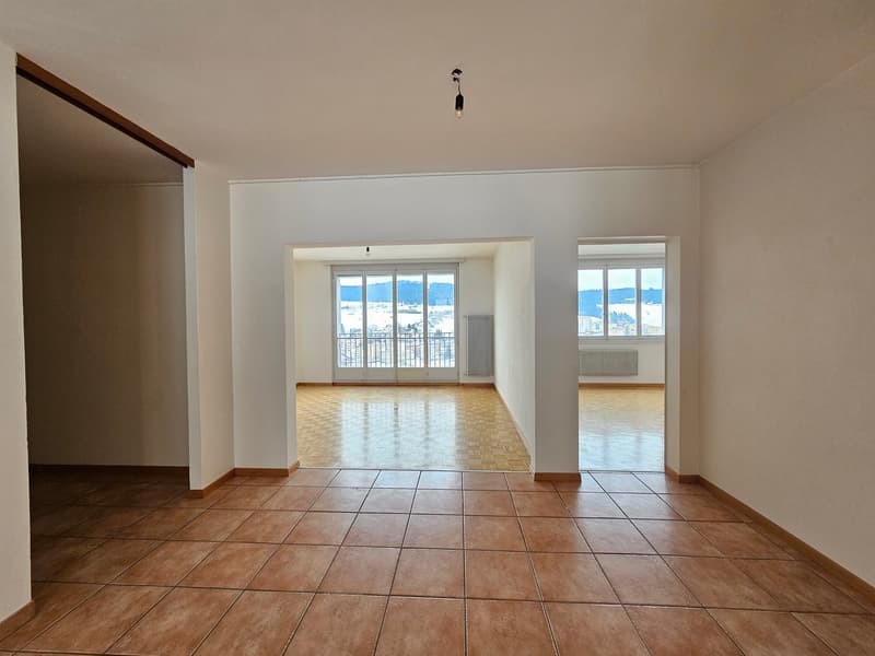 Empty room, wooden floors, large windows, balcony