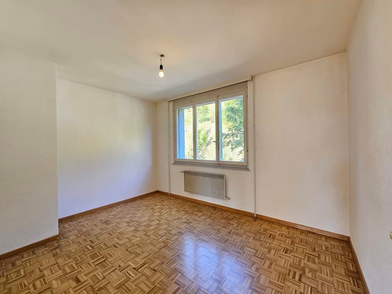 Empty room, white walls, parquet floor, window, radiator