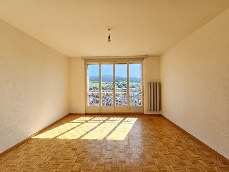 Large windows with balcony access, wooden parquet flooring, modern design, large open space, city view from the balcony
